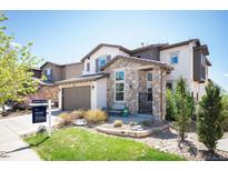 Charming two-story home featuring stone accents, a well-maintained lawn, and a cozy front porch area at 15194 W Washburn Ave, Lakewood, CO 80228