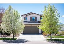 Charming two-story home with a well-manicured lawn and a two-car garage with driveway at 15194 W Washburn Ave, Lakewood, CO 80228