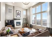 Bright living room with large windows, fireplace, and comfortable seating area at 15194 W Washburn Ave, Lakewood, CO 80228