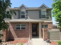 Charming townhome featuring a blend of brick and neutral siding, enhanced by well-maintained landscaping at 569 Alton Way # E, Denver, CO 80230