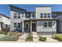 Stylish townhouse showcases modern design, landscaping, and inviting walkway to the front door at 16057 E 47Th Pl, Denver, CO 80239