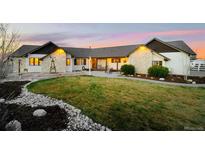 Beautiful single-story home with stone accents, well-kept lawn, and cozy patio area, perfect for outdoor living at 451 W 152Nd Ave, Broomfield, CO 80023