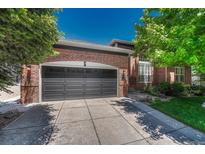 Charming brick home featuring a two-car garage and well-maintained front lawn with mature trees at 12344 Turquoise Terrace St, Castle Pines, CO 80108