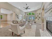 Bright living room with high ceilings, large windows, fireplace, and neutral decor at 12344 Turquoise Terrace St, Castle Pines, CO 80108