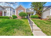 Inviting two-story home with a landscaped front yard and concrete steps leading to the entryway at 1011 S Valentia St # 30, Denver, CO 80247