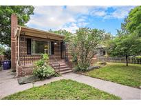 Charming brick home featuring a well-maintained lawn and inviting front porch at 2526 W 39Th Ave, Denver, CO 80211