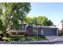 Charming home featuring brick and siding, a well-manicured lawn, beautiful foliage, and an attached two-car garage at 308 Baron Ave, Lafayette, CO 80026