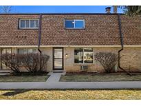 Charming exterior elevation of a two-story townhome with brick and lush green lawn at 13003 W 20Th Ave, Golden, CO 80401