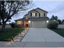 Inviting two-story home featuring a well-manicured lawn, stone walkway, and attached two-car garage at 4814 Kingbird Dr, Frederick, CO 80504