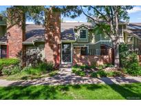Charming townhome with brick facade, mature landscaping, and welcoming front entrance at 11704 Elk Head Range Rd, Littleton, CO 80127