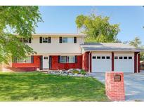 Charming two-story home with a brick facade, manicured lawn, and a two-car garage at 5332 W Roxbury Pl, Littleton, CO 80128