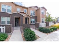 Beautiful townhome with manicured lawn and charming brick accents near the front entrance at 15443 W 65Th Ave # B, Arvada, CO 80007