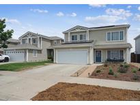 Two-story home featuring solar panels, an attached garage, landscaping, and a welcoming blue front door at 20765 E 39Th Ave, Denver, CO 80249