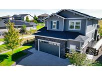 Two-story home with gray siding, stone accents, and a two-car garage at 26994 E Indore Ave, Aurora, CO 80016