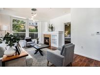 Bright living room with a fireplace, hardwood floors, and large windows at 10184 Park Meadows Dr # 1102, Lone Tree, CO 80124