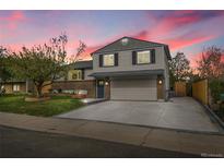 Charming two-story home with brick accents, a spacious driveway, and a well-manicured lawn at 4924 S Flower Way, Littleton, CO 80123