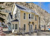 Charming yellow two-story home with bay windows and mountain views at 710 6Th St, Georgetown, CO 80444