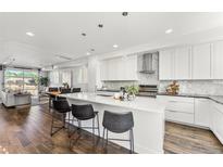 Modern kitchen with white cabinets, island, and stainless steel appliances at 163 S Harrison St, Denver, CO 80209