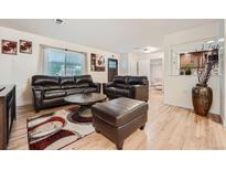 Inviting living room featuring a comfortable leather seating arrangement and stylish decor at 2701 S Knox Ct, Denver, CO 80236