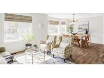 Bright living area featuring a bay window, hardwood floors, and elegant decor with a dining space at 6385 S Nelson Way, Littleton, CO 80127