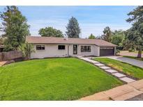 Charming ranch home with updated exterior and landscaped lawn at 5576 E Lehigh Ave, Denver, CO 80237