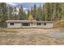 Ranch style home with gray siding, nestled in a wooded setting at 483 Tonn Vly, Evergreen, CO 80439
