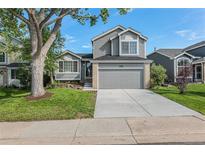 Charming two-story home with a well-maintained lawn, mature tree and attached two car garage at 5068 E Crestone Ave, Castle Rock, CO 80104