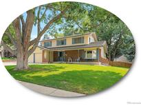 Charming two-story home with a well-manicured lawn and mature trees at 2576 S Cody Way, Lakewood, CO 80227