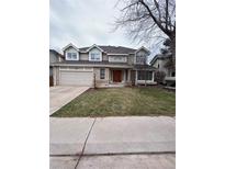 Inviting two-story home featuring a brick and siding exterior, complemented by a well-manicured lawn and attached two car garage at 5151 S Laredo Ct, Centennial, CO 80015