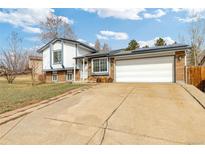 Charming home featuring brick accents, solar panels, an attached two-car garage, and a long concrete driveway at 9605 W David Ave, Littleton, CO 80128