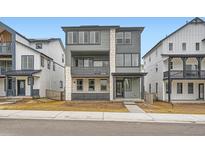 Modern two-story home with gray siding and stone accents, complemented by well-manicured landscaping at 7308 Waterleaf Trl, Littleton, CO 80125