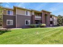 Inviting condo complex featuring manicured lawn, brick accents, and a neutral color palette at 8481 W Union Ave # 13203, Denver, CO 80123