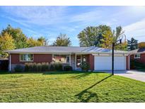 Charming one-story brick home with a well-maintained lawn, mature trees, and a basketball hoop at 2546 S Stuart St, Denver, CO 80219