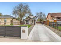 Charming home featuring a long driveway, dark trim, and a manicured front yard at 825 S Quitman St, Denver, CO 80219