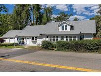Charming single-story home featuring white siding, gray shingle roof, and lush landscaping at 5195 Allison St, Arvada, CO 80002