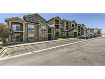 Beautiful exterior of apartments with balconies, stone accents, and parking spots at 18657 Stroh Rd # 4103, Parker, CO 80134