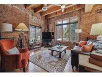 Spacious living room with exposed brick walls and hardwood floors at 2960 Inca St # 120, Denver, CO 80202