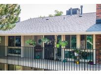 A charming balcony with black iron railings is adorned with an array of colorful flowers and plants at 6495 E Happy Canyon Rd # 163, Denver, CO 80237