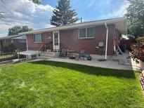 Charming brick ranch-style home with a well-maintained lawn and outdoor seating area, perfect for relaxing or entertaining at 25 S Winona Ct, Denver, CO 80219