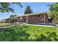 Charming brick home with a well-maintained front yard and cozy outdoor seating area at 25 S Winona Ct, Denver, CO 80219