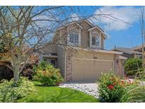 Charming two-story home featuring a well-manicured lawn, beautiful landscaping, and a two-car garage at 8884 Miners St, Highlands Ranch, CO 80126