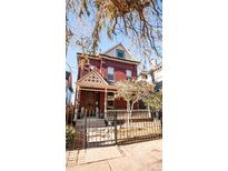 Charming brick home featuring a well-maintained yard with mature trees and a wrought-iron fence at 2335 Stout St, Denver, CO 80205