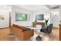 Bright living room featuring a modern design, wood floors, and large windows for natural light at 3663 S Sheridan Blvd # H15, Denver, CO 80235