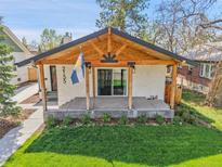 Charming home featuring a covered porch with wooden beams and a well-manicured lawn at 2155 S Emerson St, Denver, CO 80210