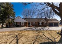 Charming one-story brick home with a well-manicured lawn, mature trees, and a welcoming driveway at 22 Wedge Way, Littleton, CO 80123