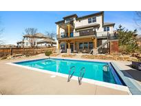 Back exterior of luxurious home with a beautiful pool and a built-in ladder for entry at 10057 S Shadow Hill Dr, Lone Tree, CO 80124