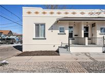 Charming home showcasing a beautifully landscaped yard and inviting front porch with black iron railings at 719 W 7Th Ave, Denver, CO 80204