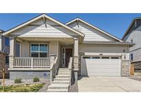 Charming home featuring a covered porch, stone accents, and a two-car garage at 1159 Sunrise Dr, Erie, CO 80516