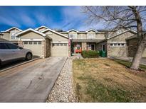 Charming townhome with stone accents, an attached garage, and well-maintained landscaping at 9267 Welby Rd Ter, Denver, CO 80229