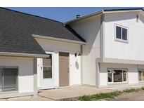 Exterior view of home featuring a black roof, light colored siding, and a brown front door at 3051 Craft Way # 2, Westminster, CO 80030